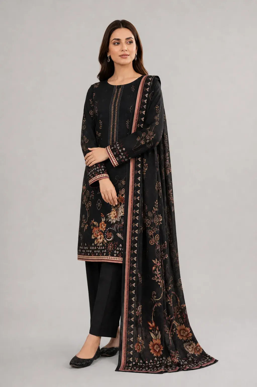 Woman wearing a black shalwar kameez outfit with a matching dupatta on a gray background