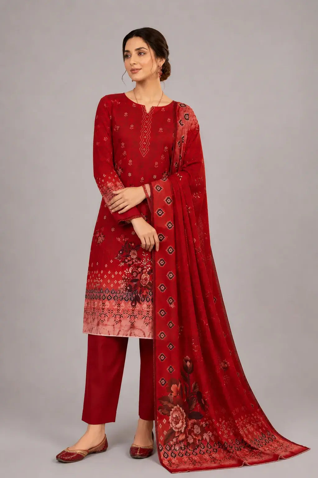 Woman wearing a red digital printed suite with a matching dupatta on a gray background
