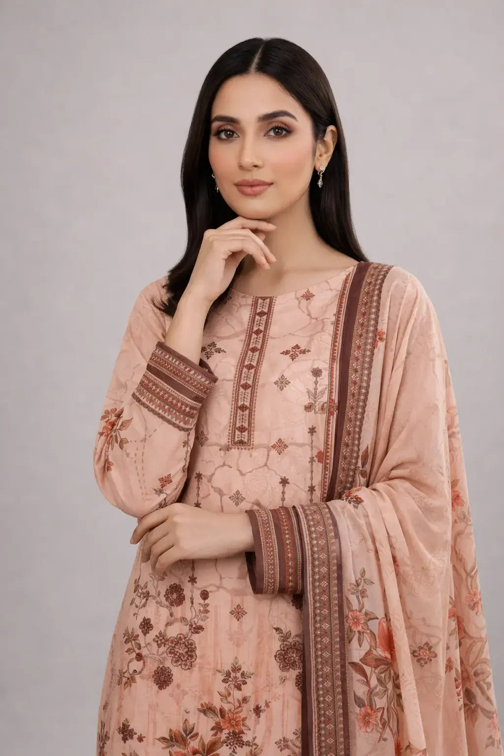 Woman wearing a pink Pakistani Dress design with intricate patterns on a gray background