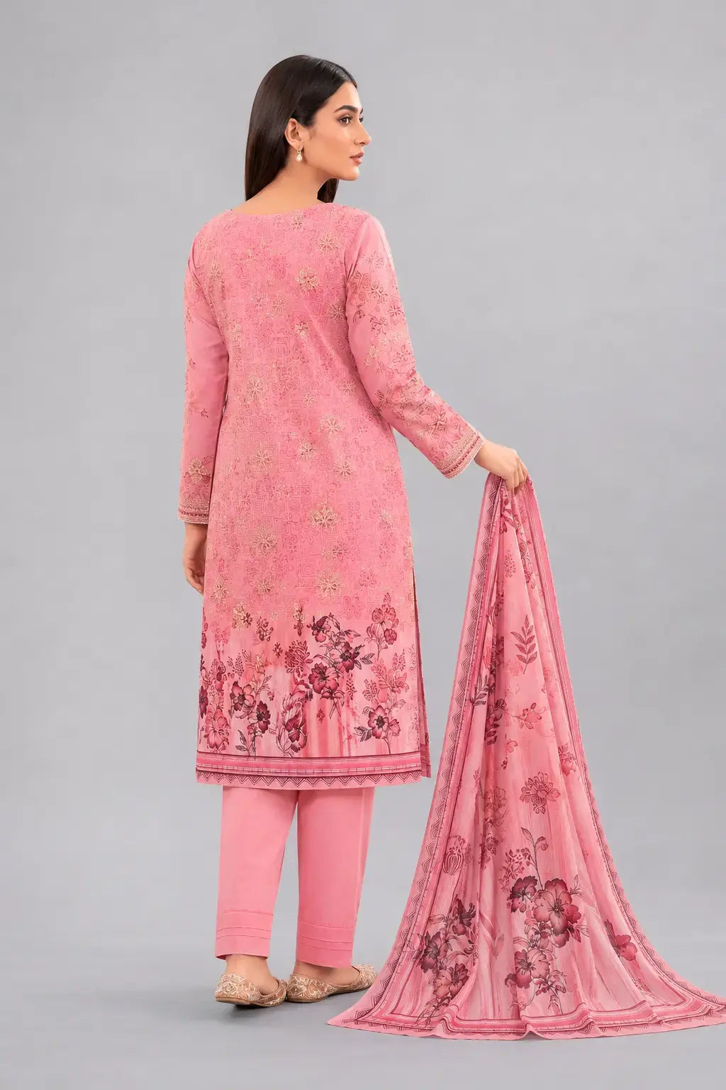 Woman wearing a pink Pakistani dress design in luxury lawn fabric with a matching dupatta and plain trouser