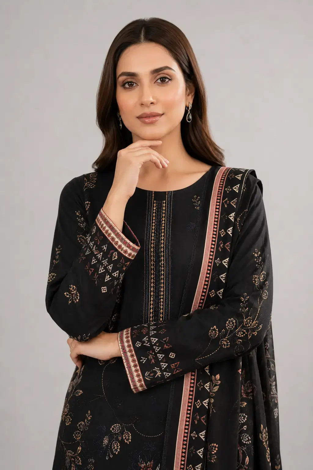 Woman wearing a black printed traditional dress with a plain background