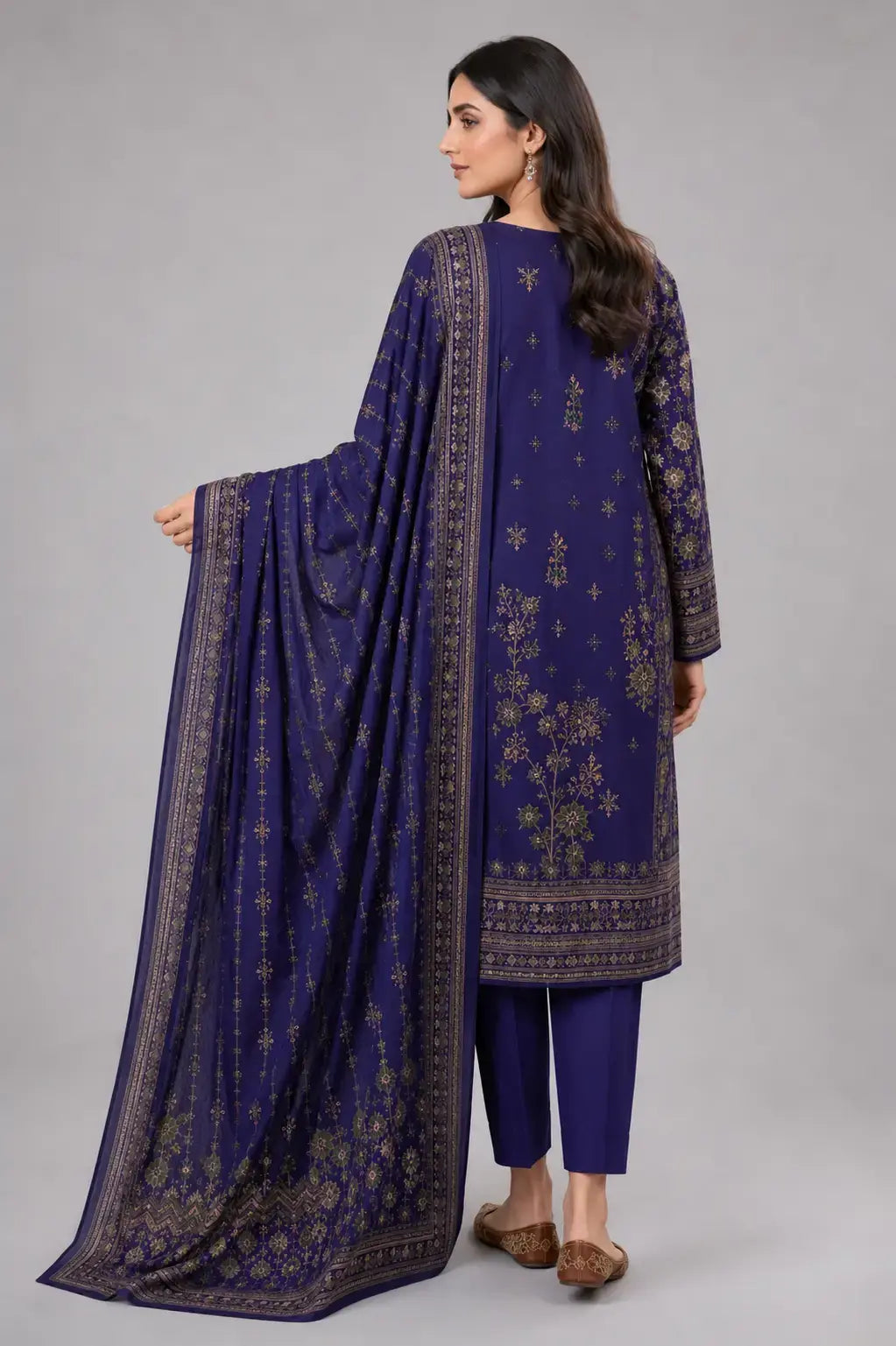 Woman wearing a traditional blue outfit with a matching dupatta on a gray background